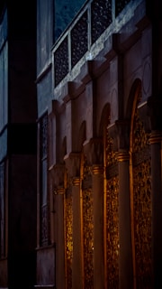 Close-up of a sandstone column featuring subtle laurel carvings with warm golden light