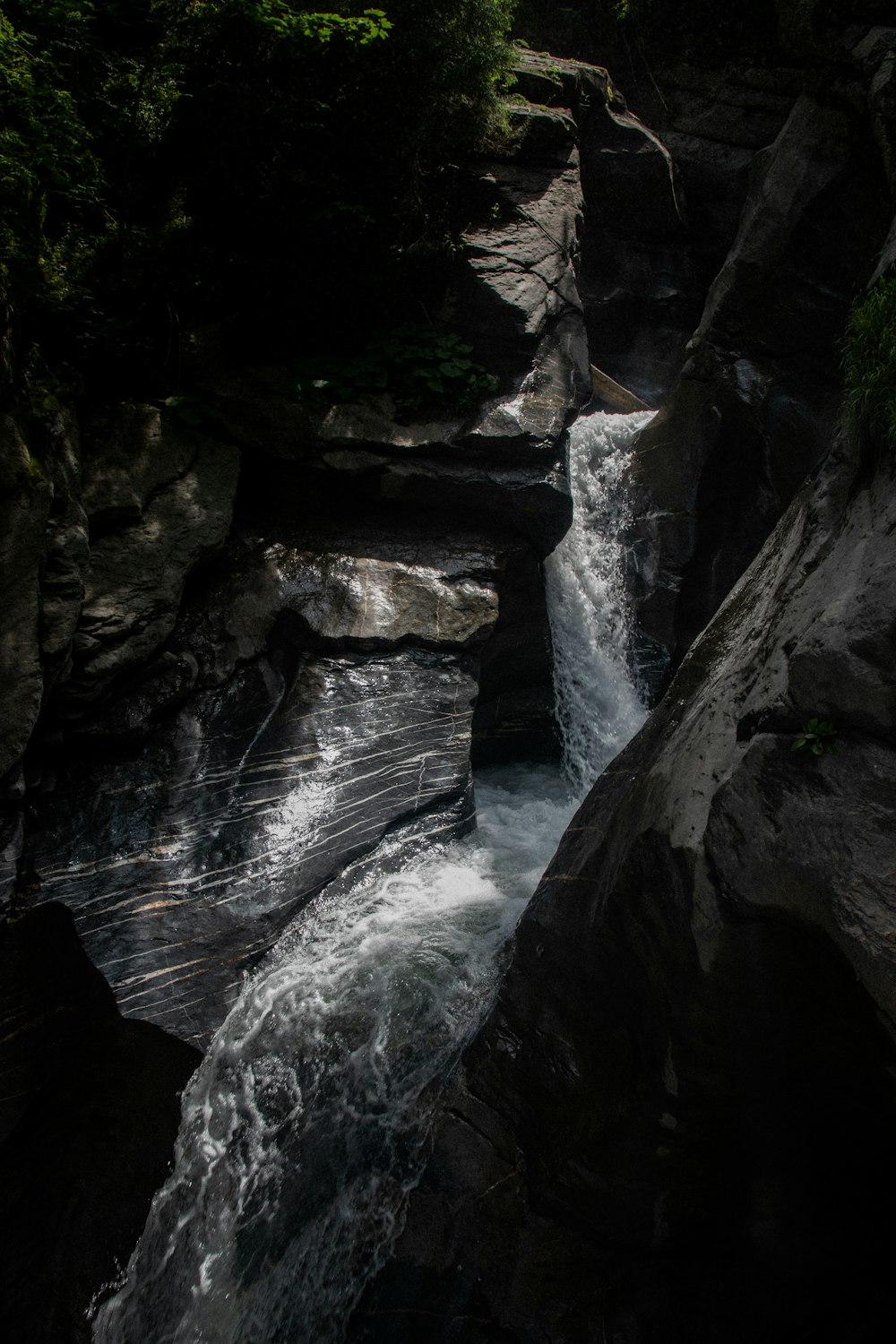 water falls between brown rocks