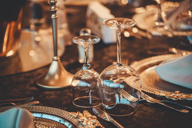 A cozy table setting featuring a variety of elegant wine and drink glasses from vinolume, catching the light beautifully.