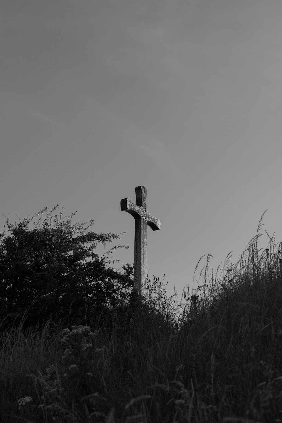grayscale photo of cross on top of pole