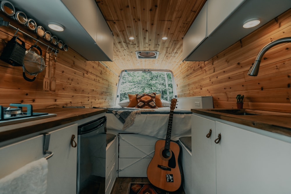 brown acoustic guitar on black steel stand