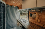 Interior view of a food truck kitchen showing stainless steel counters and installed appliances.