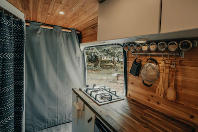 Interior view of a food truck kitchen showing stainless steel counters and installed appliances.