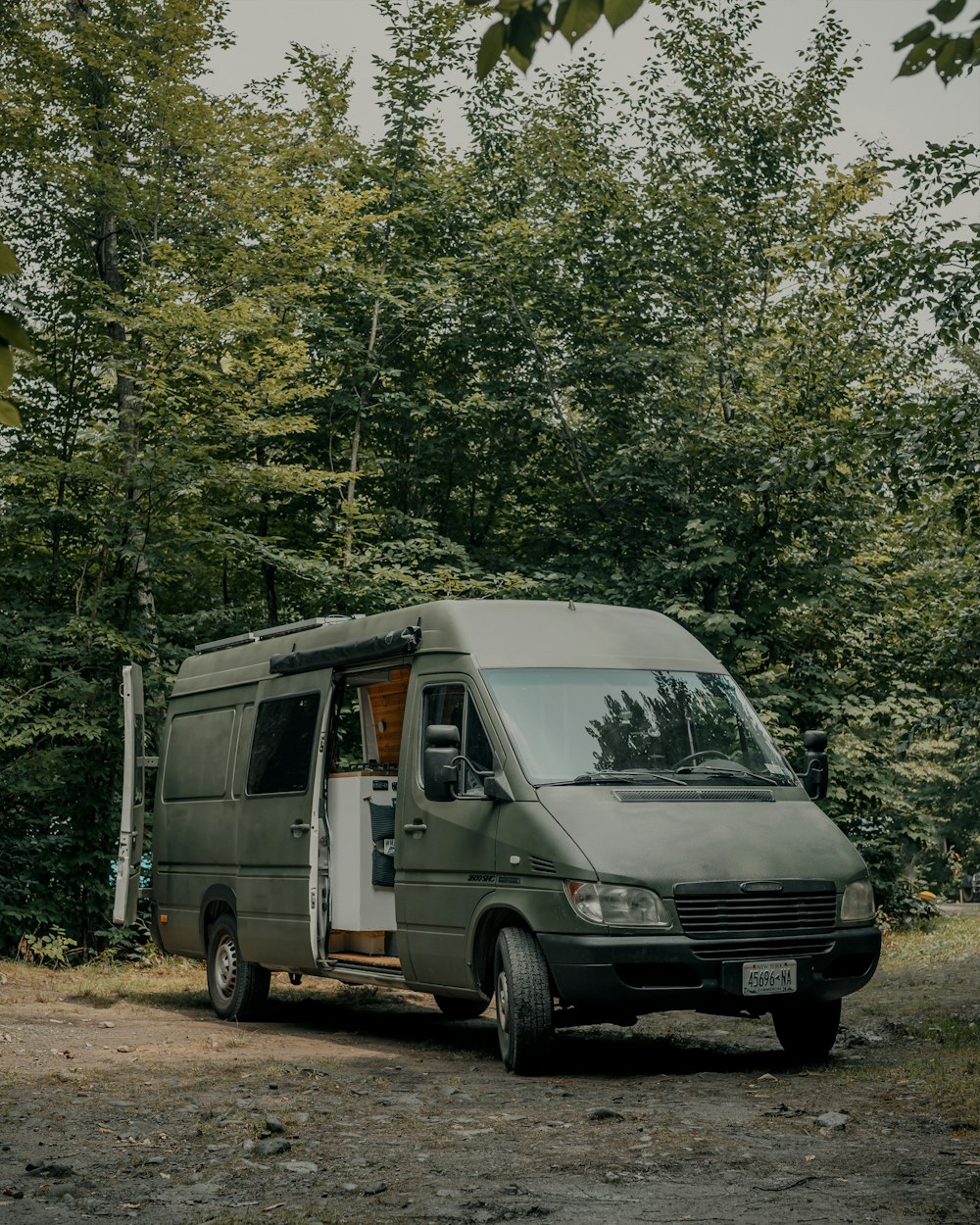 white van parked near green trees during daytime