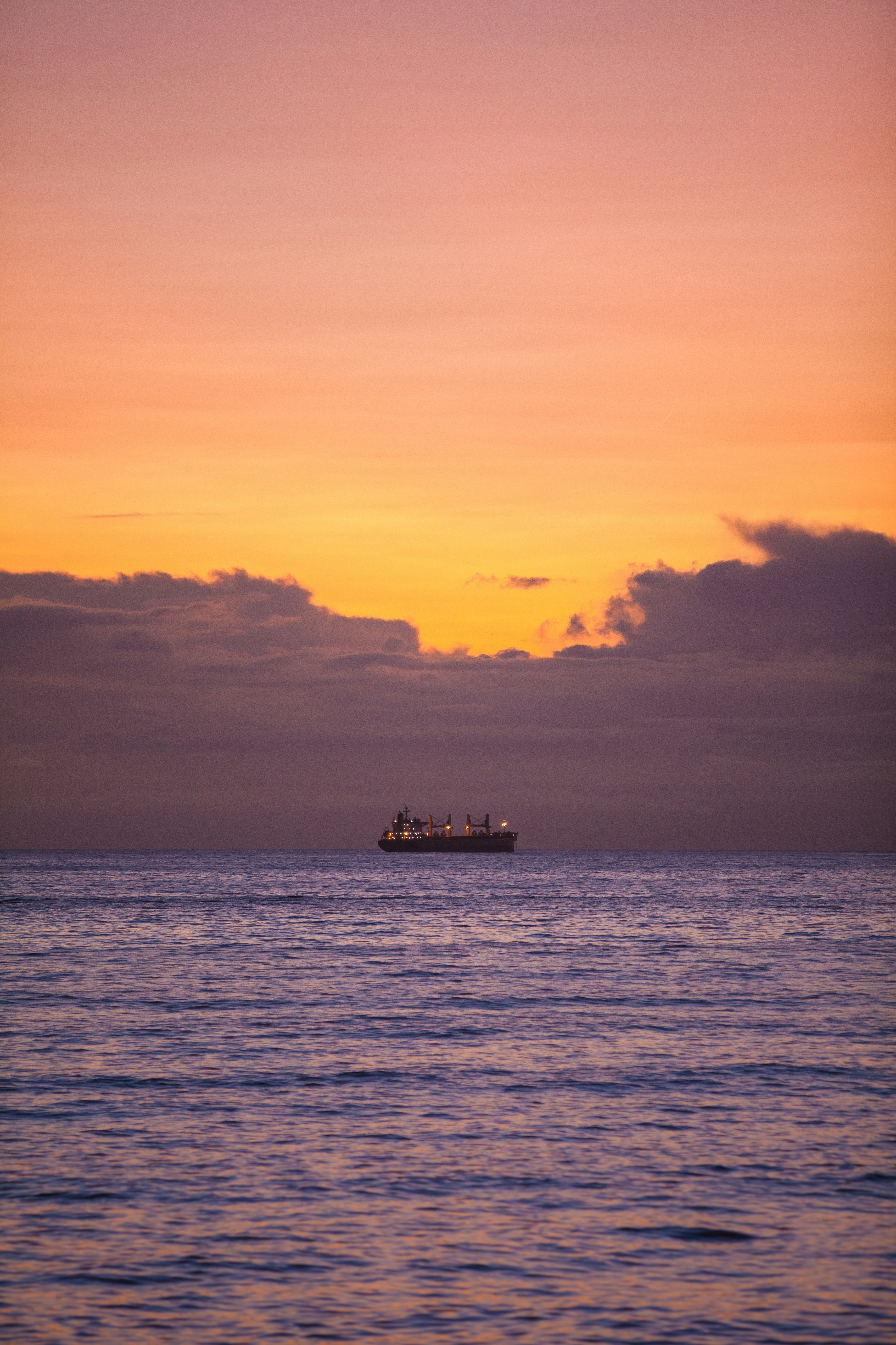 silhouette of ship on sea during sunset