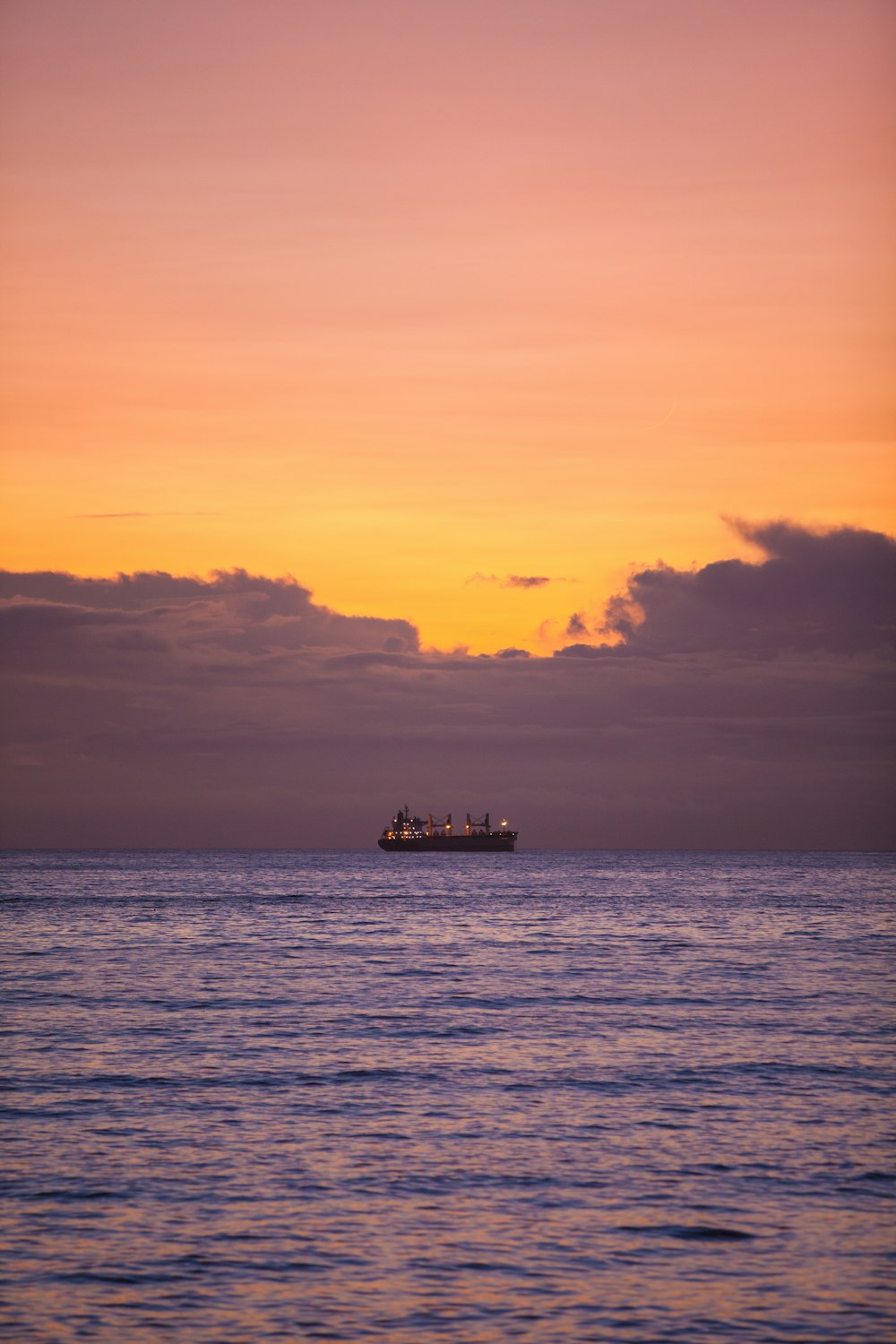 silhouette of ship on sea during sunset
