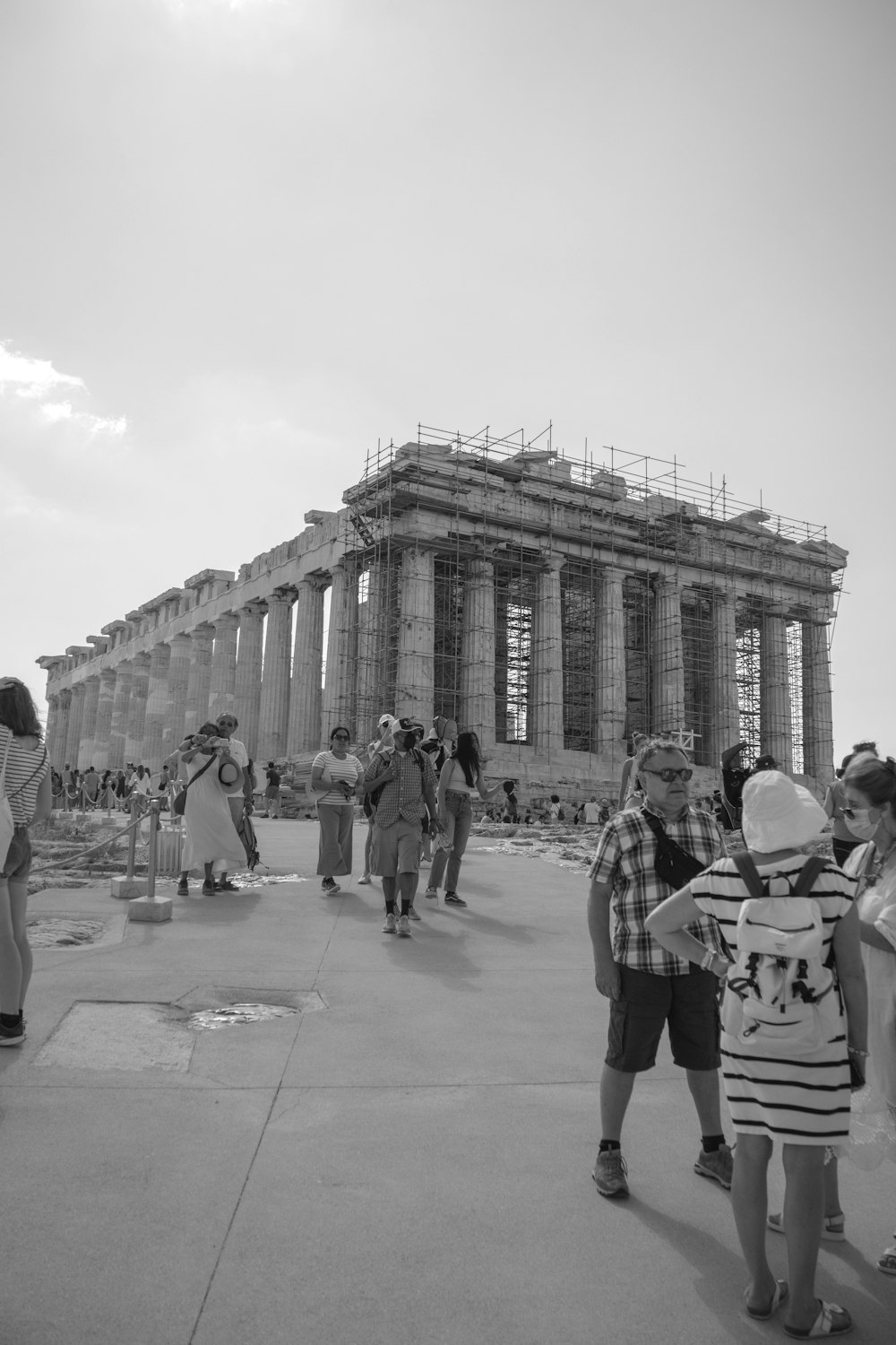 grayscale photo of people walking near building