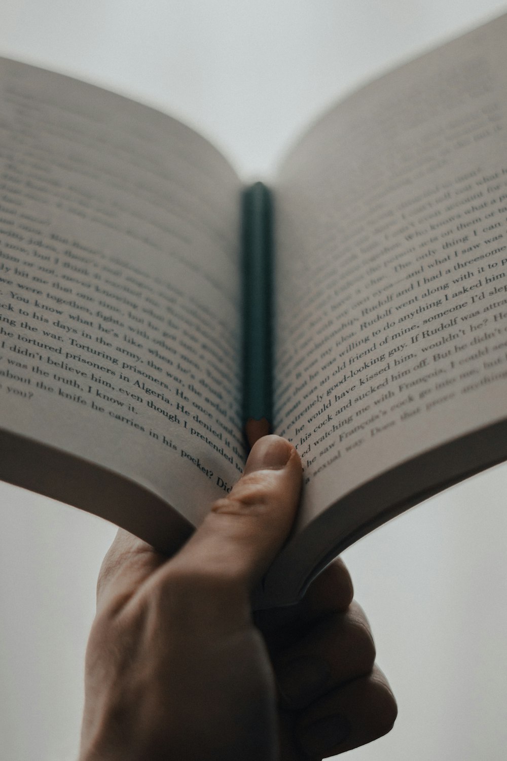 person holding blue pen on book page