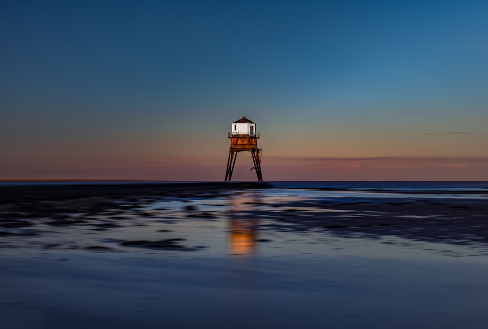 white lifeguard house on beach during sunset