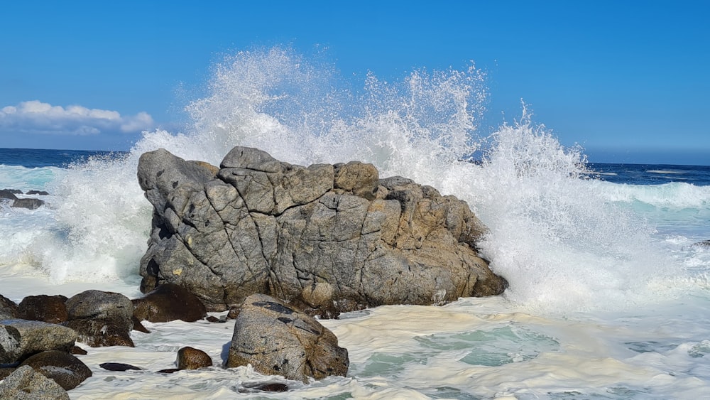 brown rock formation on body of water during daytime