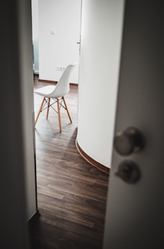 brown wooden chair beside white wall