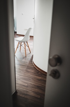 brown wooden chair beside white wall