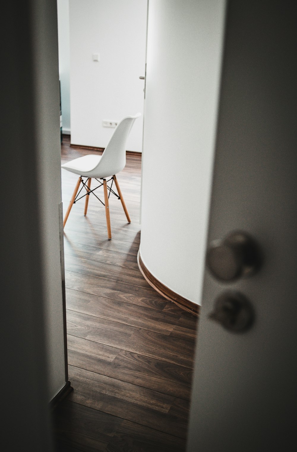 brown wooden chair beside white wall