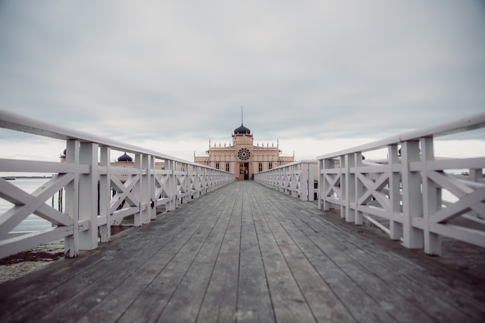 brown wooden dock with white metal railings