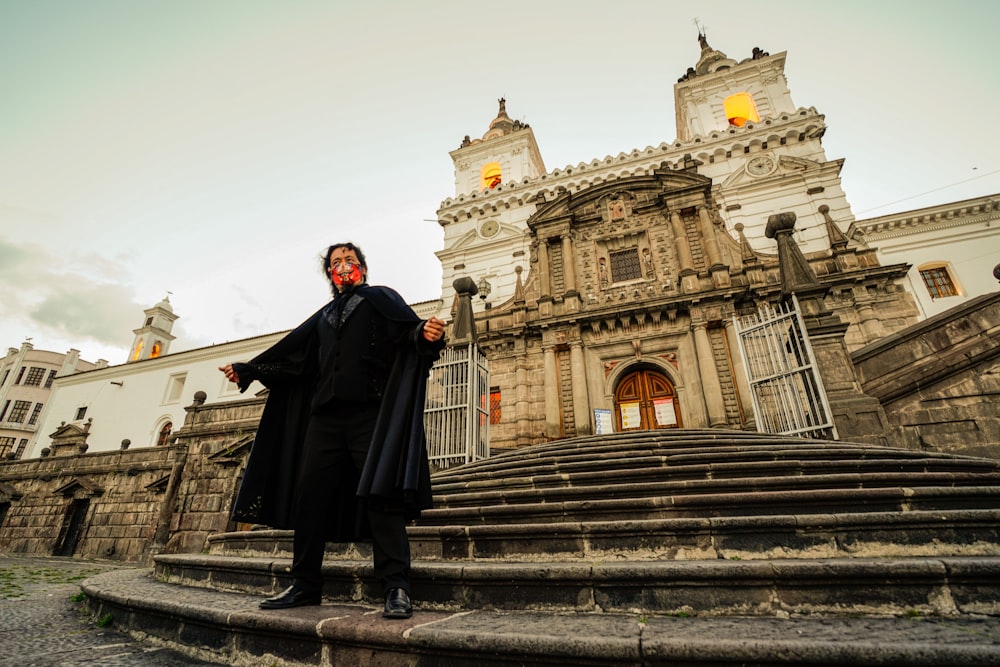 man in black thobe standing on stairs