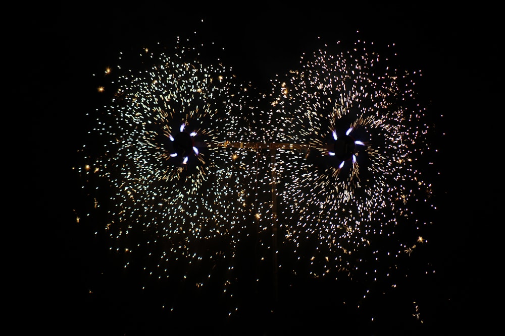 white and yellow fireworks in the sky during night time