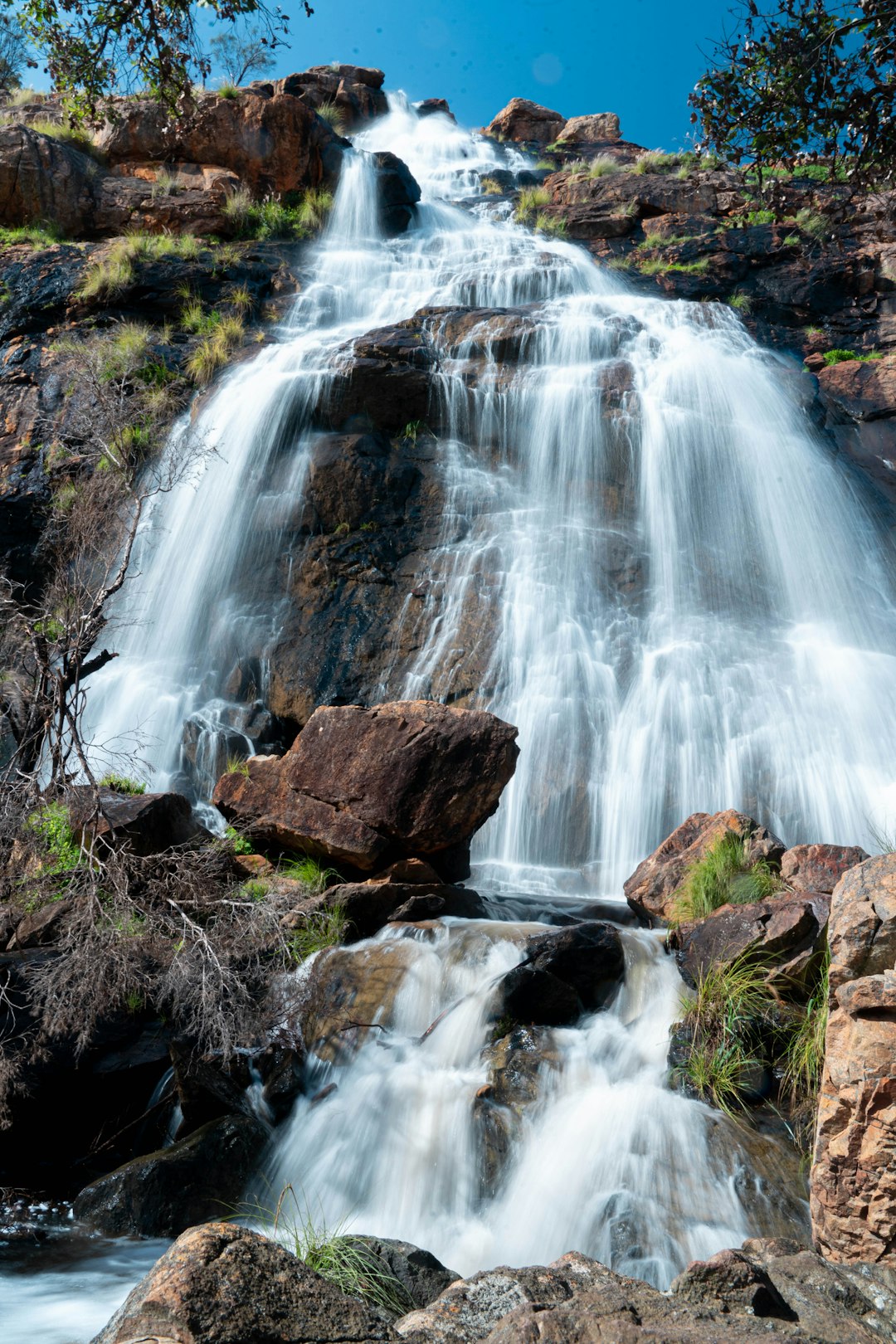 water falls on brown rocky mountain during daytime