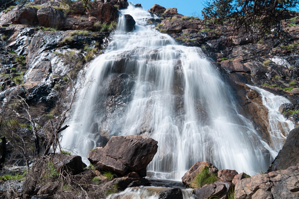 waterfalls on brown rocky mountain during daytime