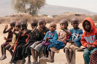 children sitting on brown sand during daytime