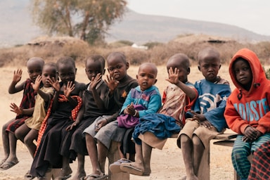 photography poses for big groups,how to photograph children sitting on brown sand during daytime