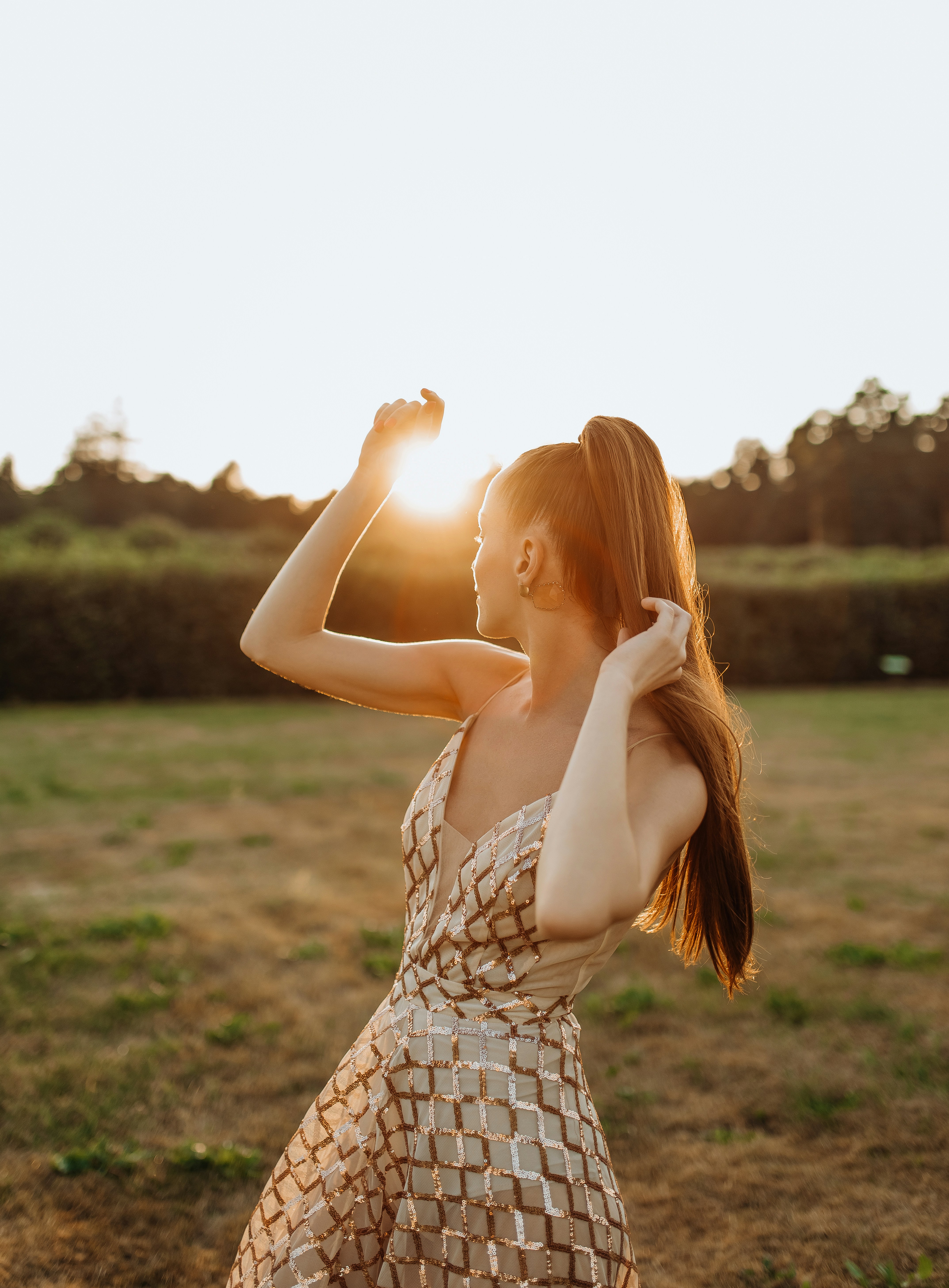 woman in white and black stripe tank dress standing on green grass field during daytime