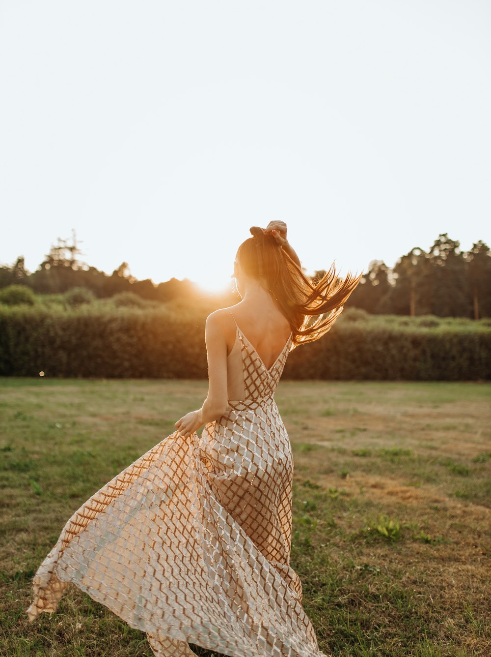 woman in white and red dress standing on green grass field during daytime