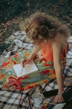 woman in orange tank top sitting on white and black textile