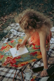 woman in orange tank top sitting on white and black textile