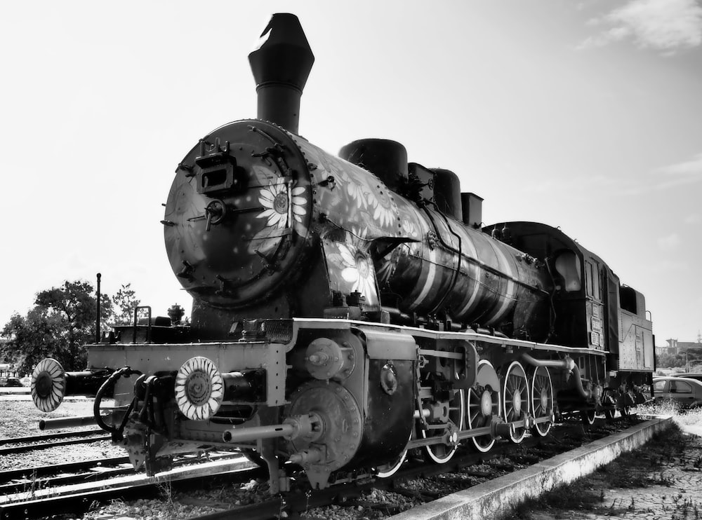 black and gray train on rail tracks under white sky during daytime
