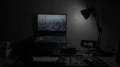 A freelancer working late with glowing laptop and colorful ambient lights.