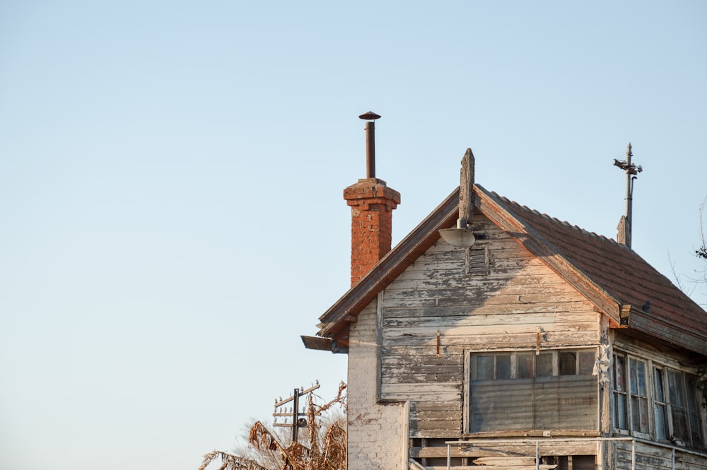 brown wooden house near bare trees during daytime