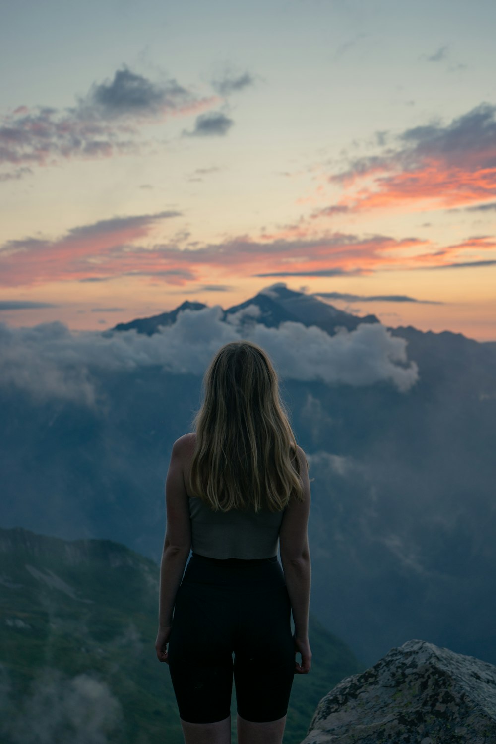 woman in black tank top standing on top of mountain during daytime