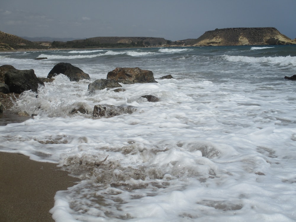 ocean waves crashing on shore during daytime