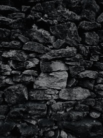 A beautifully crafted retaining wall blending black stone and silver metal accents under soft lighting.