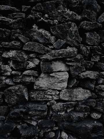 A beautifully crafted retaining wall blending black stone and silver metal accents under soft lighting.