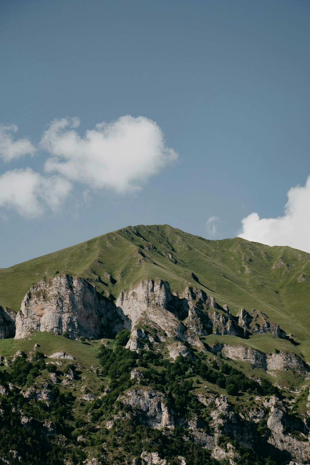 green and gray mountain under white clouds and blue sky during daytime