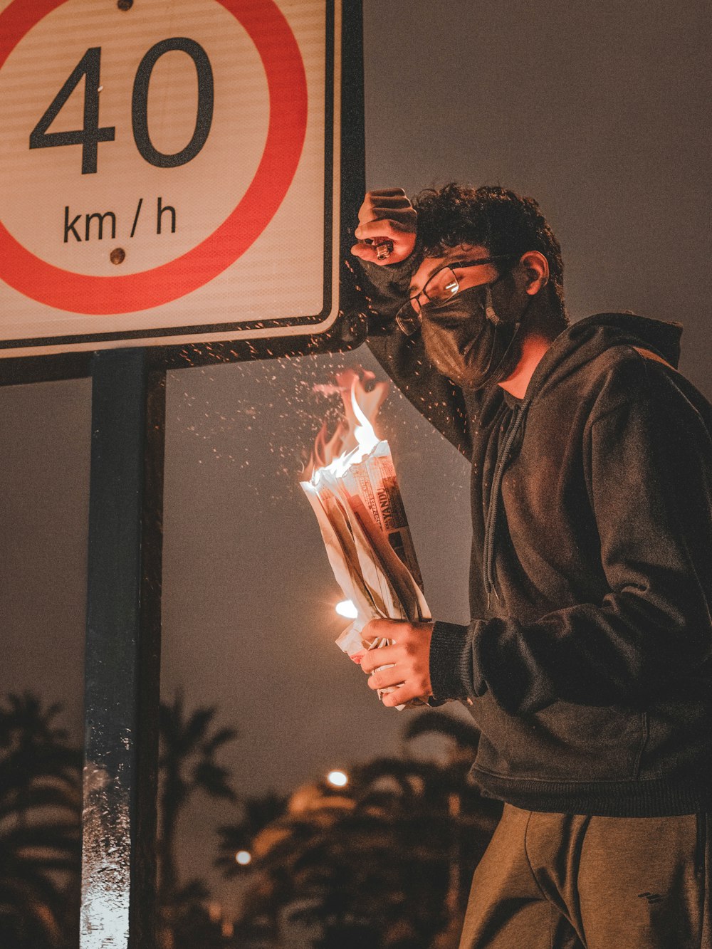 man in black jacket holding fire