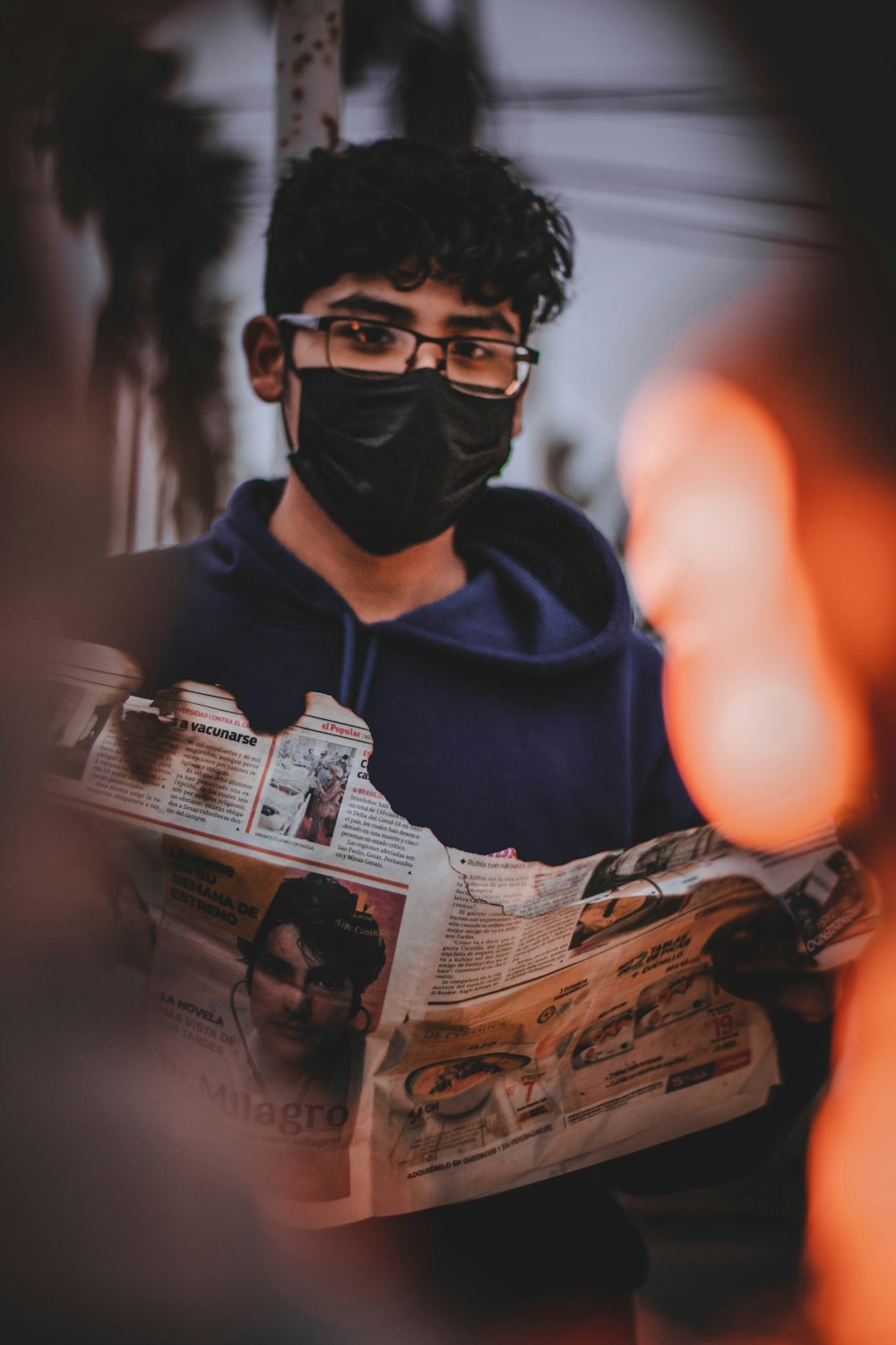 man in black hoodie holding a magazine
