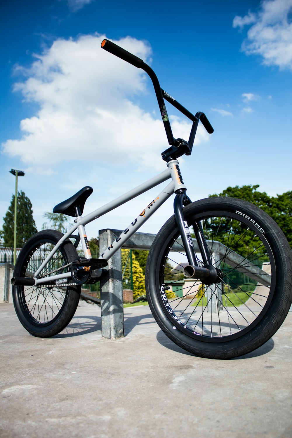 A BMX bicycle is parked next to a skating rail