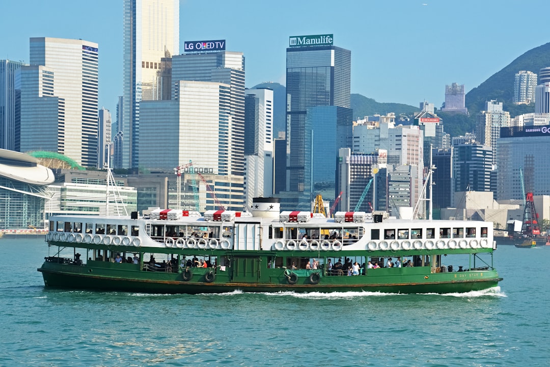 white and green cruise ship on sea near city buildings during daytime