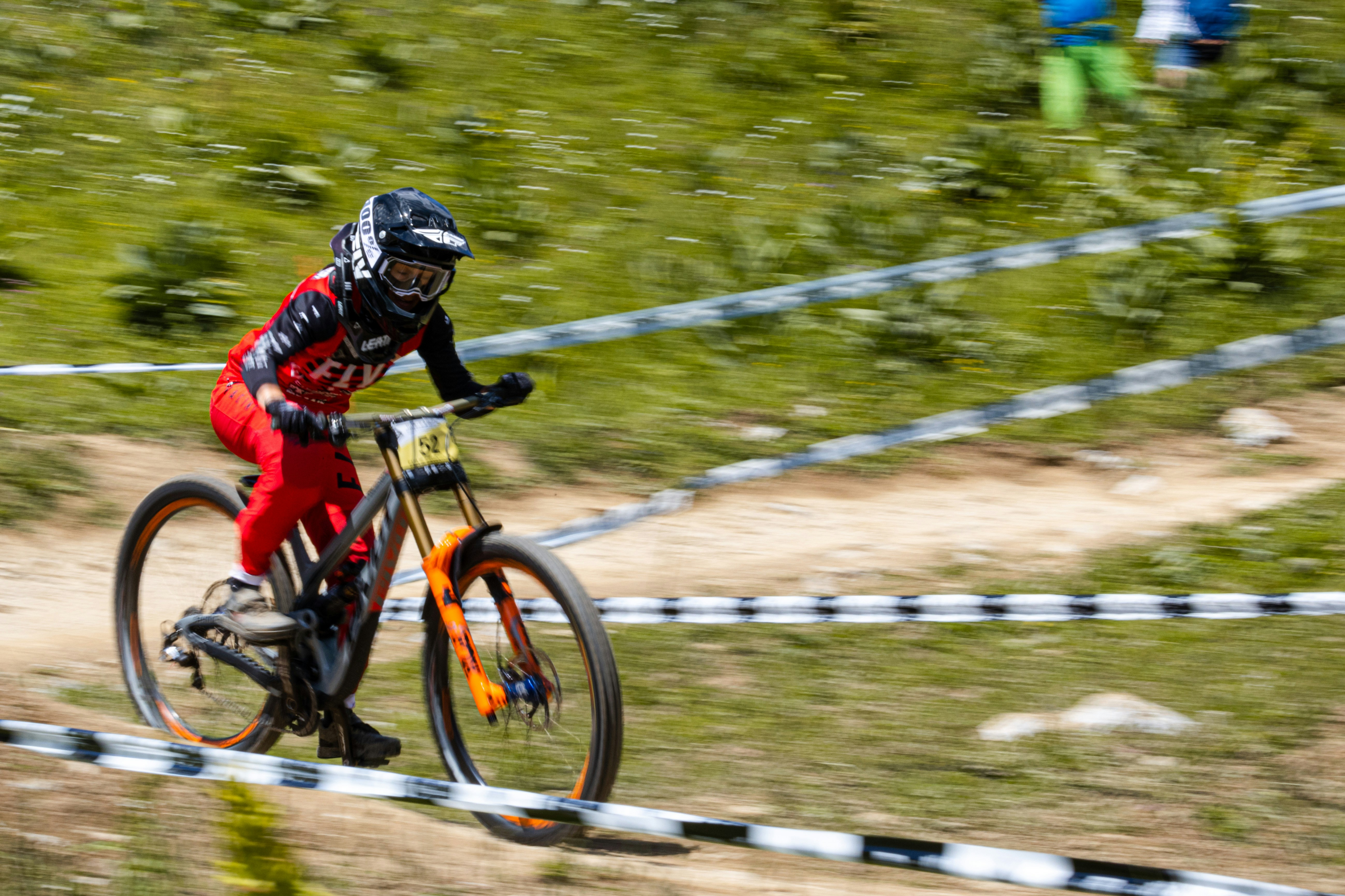 man in red and black jacket riding on bicycle during daytime