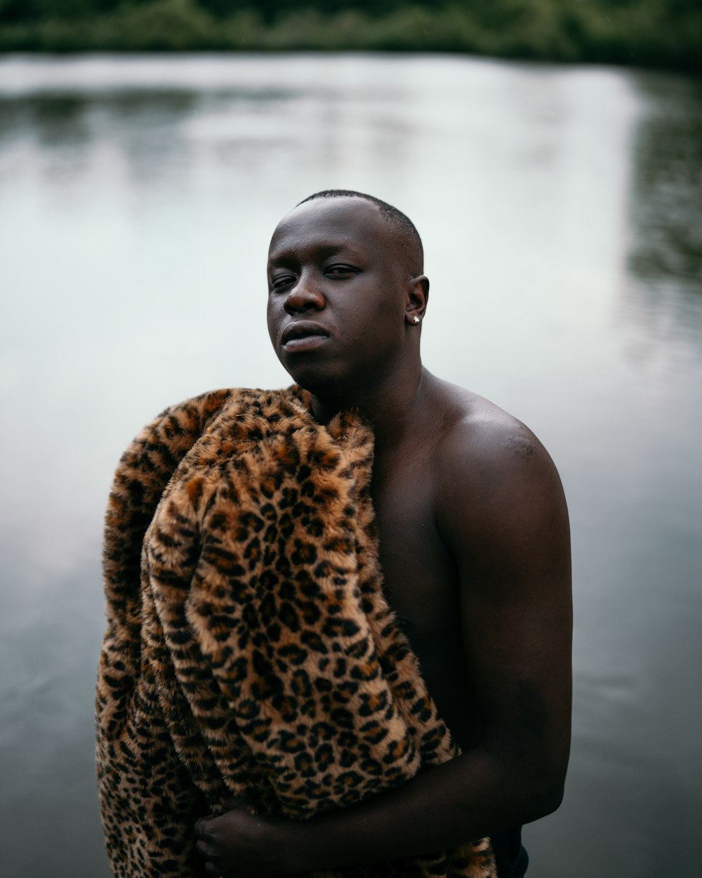 man covered with brown and black leopard blanket