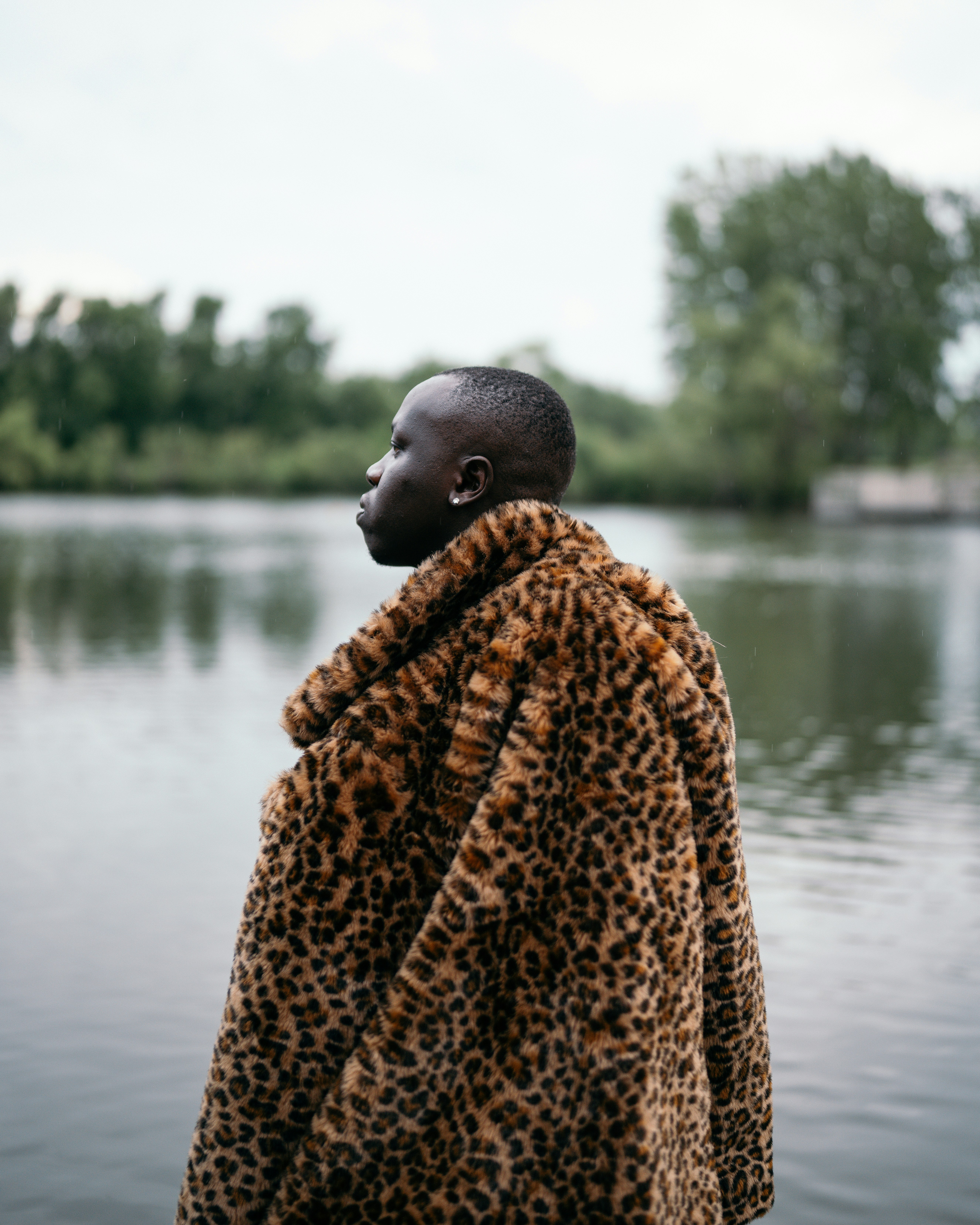 man covered with brown and black leopard blanket
