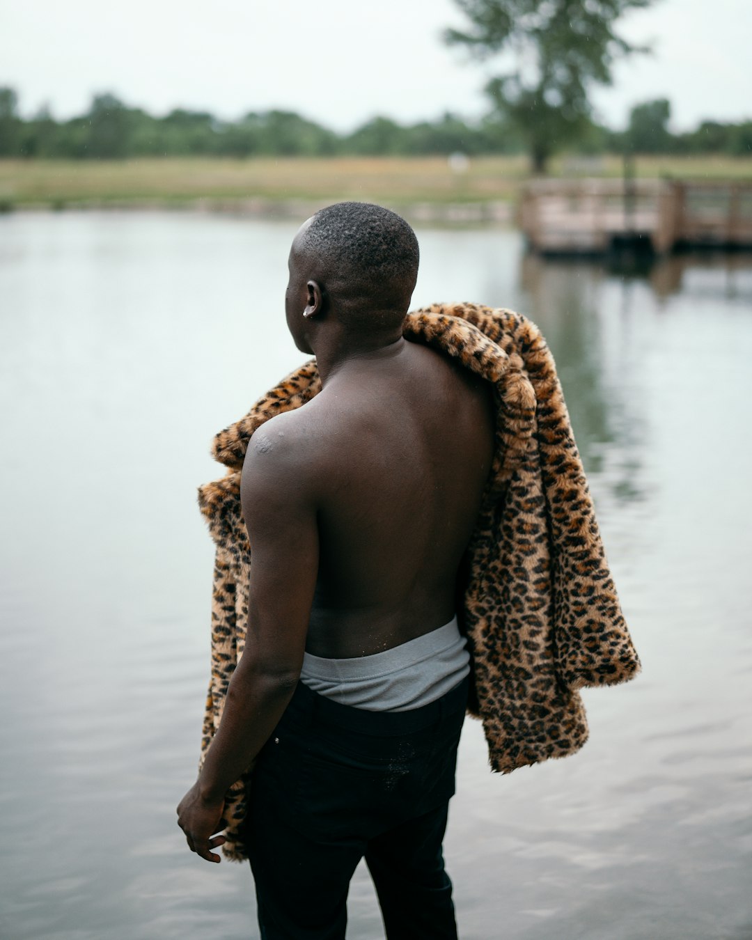 man in black shorts standing beside body of water during daytime