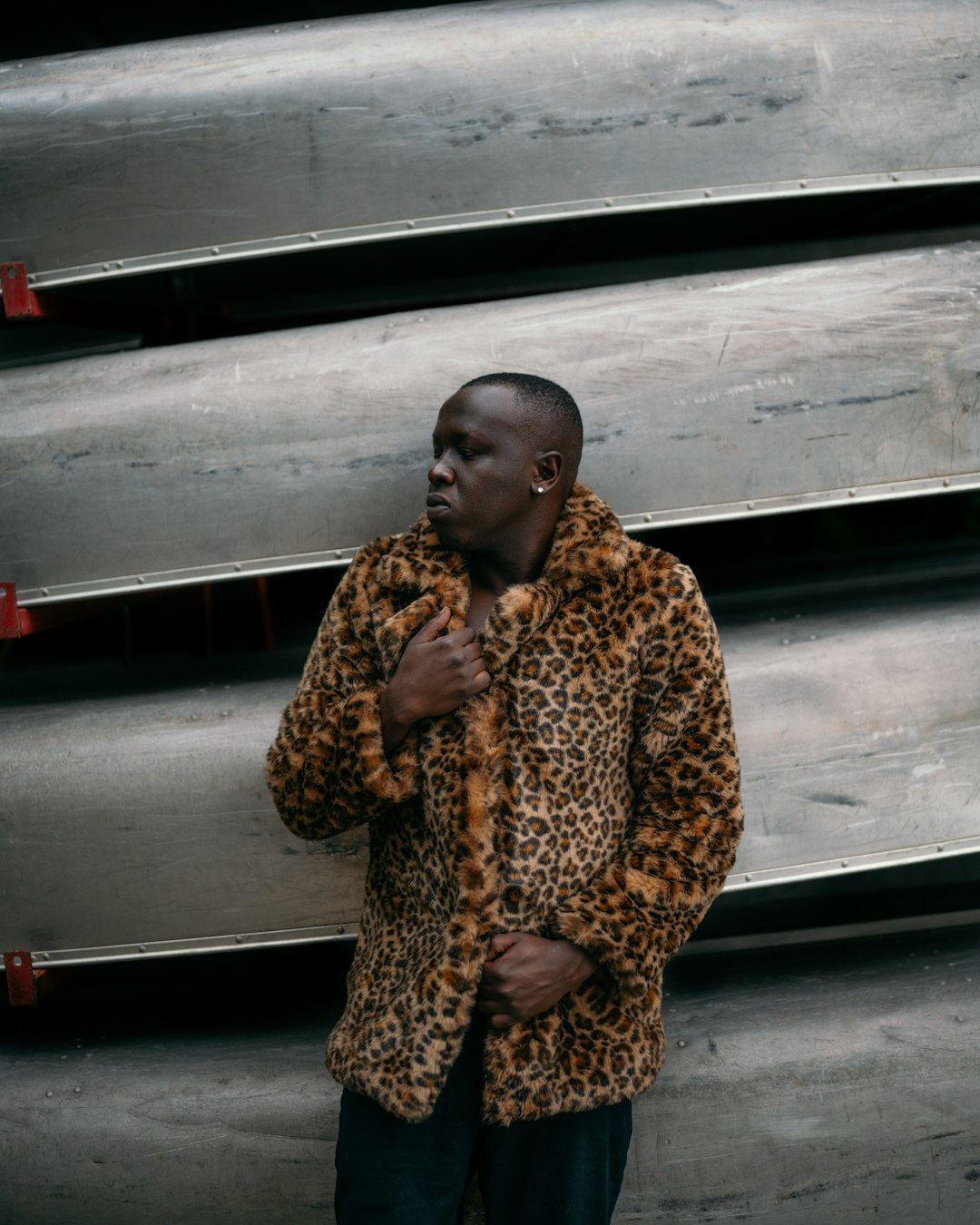 woman in brown and black leopard coat standing beside white wall