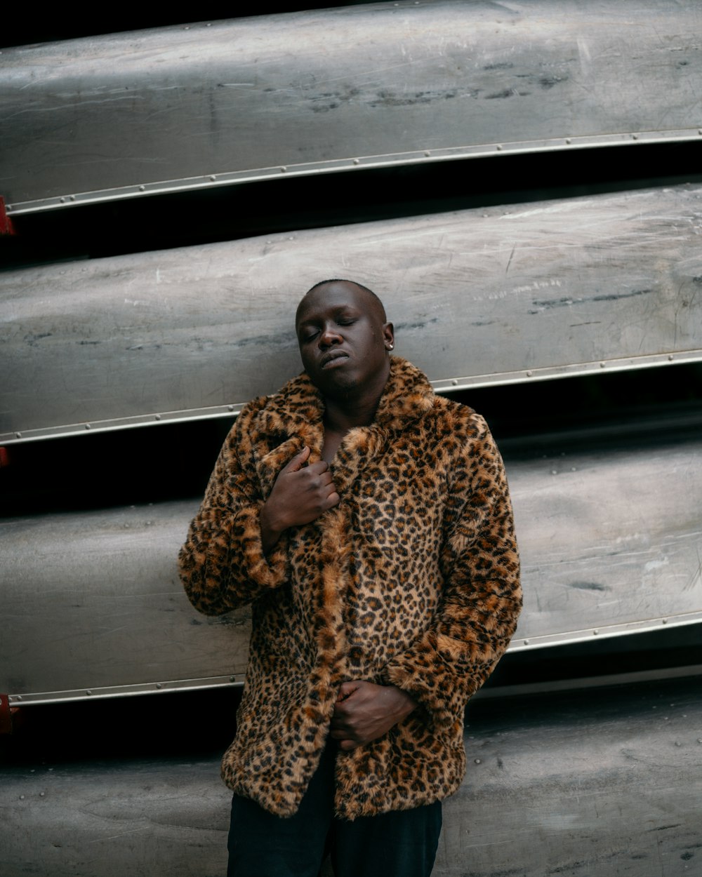 woman in brown and black leopard coat standing beside white wall