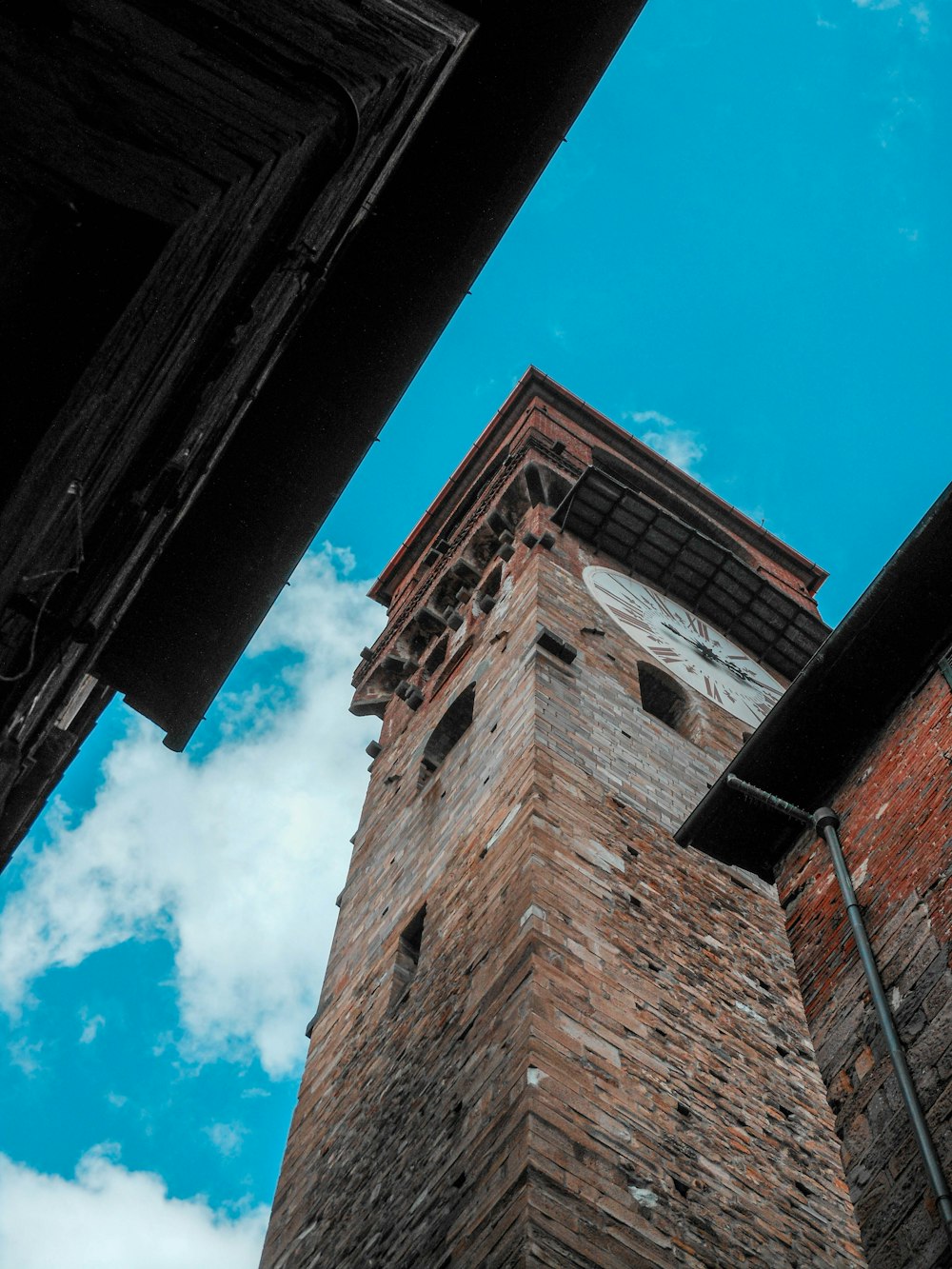 昼間の青空の下での茶色のレンガ造りの建物のローアングル写真