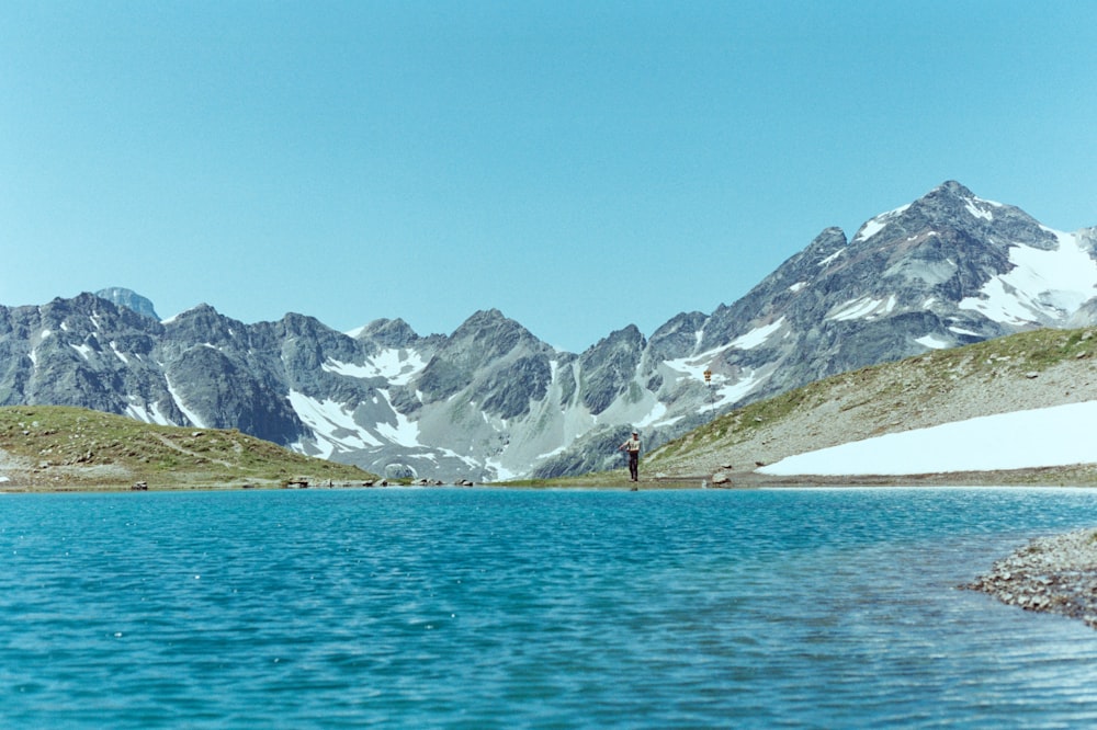 snow covered mountain near body of water during daytime