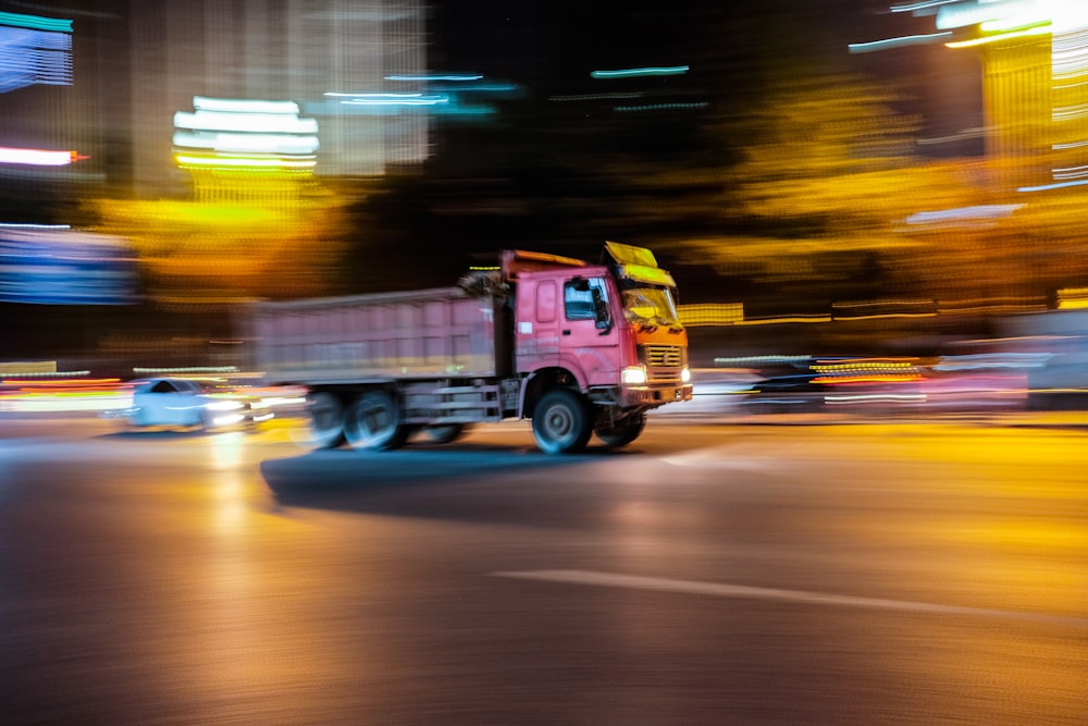 camion rouge et jaune sur la route pendant la nuit