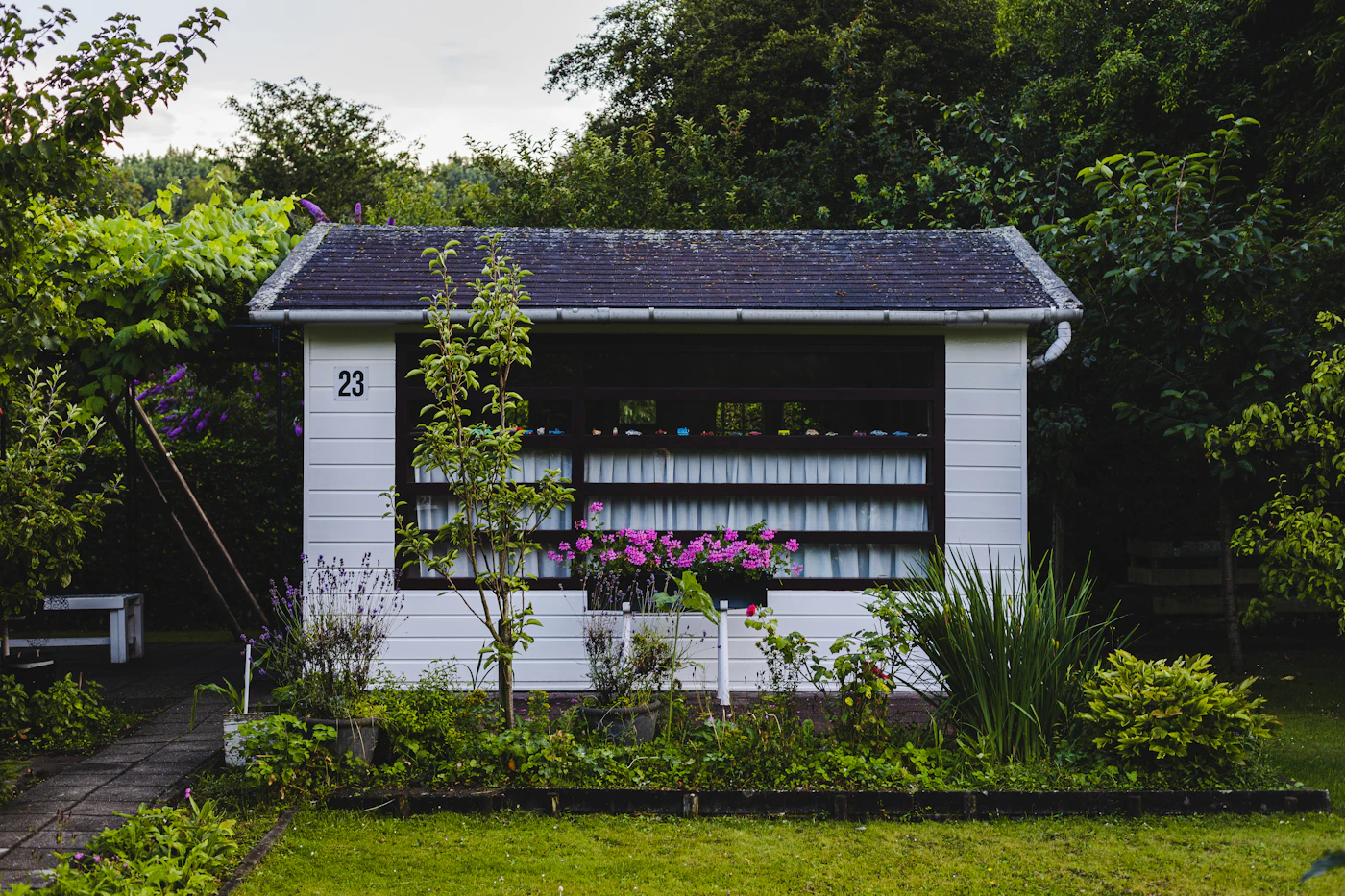White backyard studio shed on a green lawn